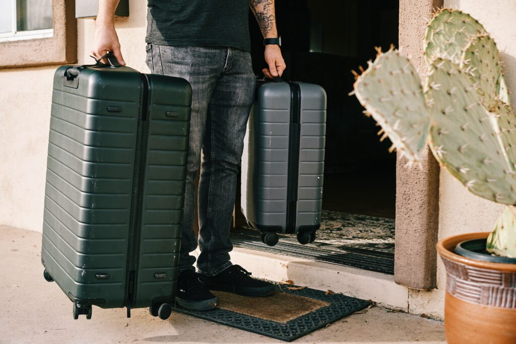 Young man moving into new home carrying luggage